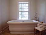 A bathtub sits in the "hers" bathroom in the master suite of