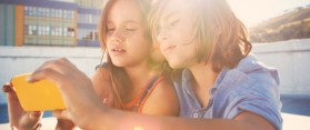 Girl and boy (8-10) looking at smart phone