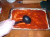 Spreading the sauce over the dough