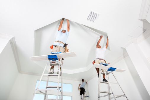 Two men installing crown molding