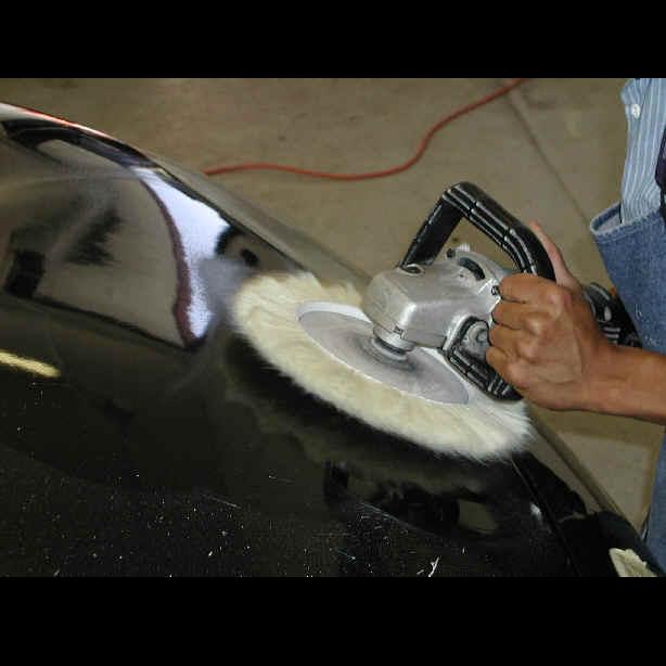 A buffer being used to wax a car