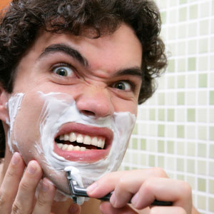 Man Shaving With Razor