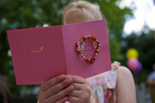 Girl reading pink birthday card
