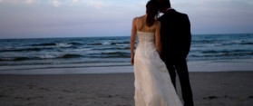 Bride and groom on beachrear view