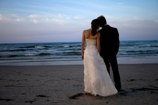 Bride and groom on beachrear view