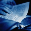 Hands on page of Bible, close-up.