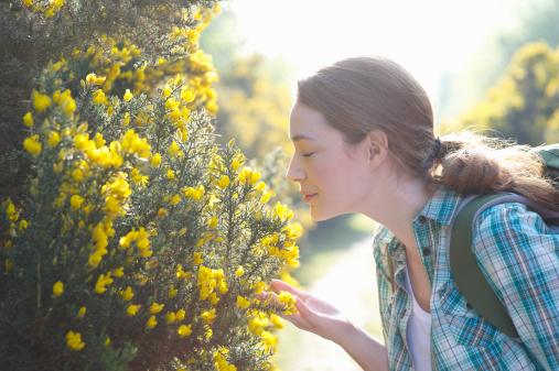 Woman smelling flowers in countryside.