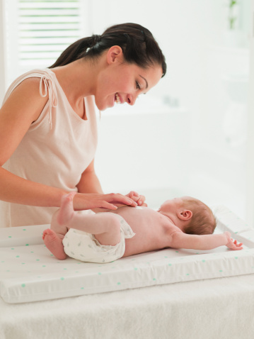 Mother changing baby's diaper