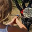 Girl aiming a target with crossbow, in garden