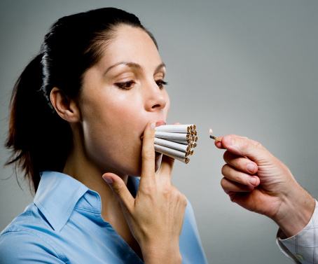 Woman with multiple cigarettes in mouth, man holding match