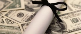 Rolled diploma and mortar board with US banknotes inside