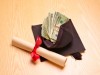 Rolled diploma and mortar board with US banknotes
