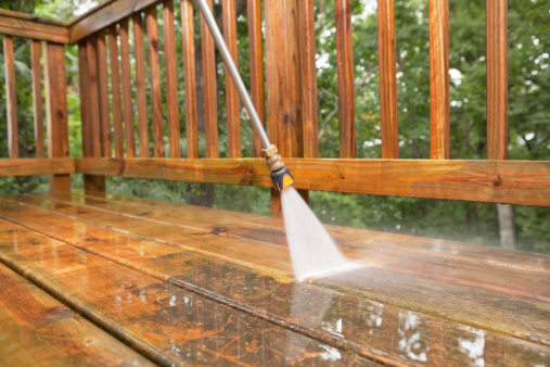 Pressure Washer Cleaning a Weathered Deck