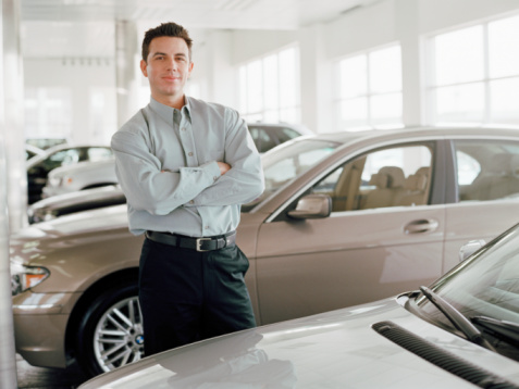 Man standing between cars in dealership