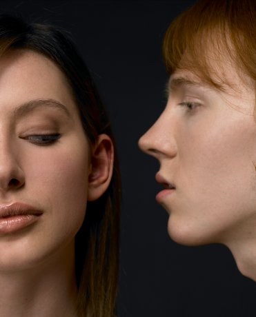 Man whispering in woman's ear
