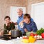 Father and teenage sons in kitchen by stove