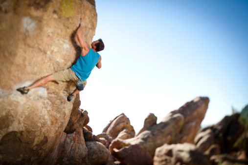 Male rock climber bouldering.