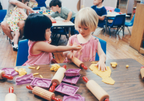 TWO GIRLS PLAYING IN CLASSROOM