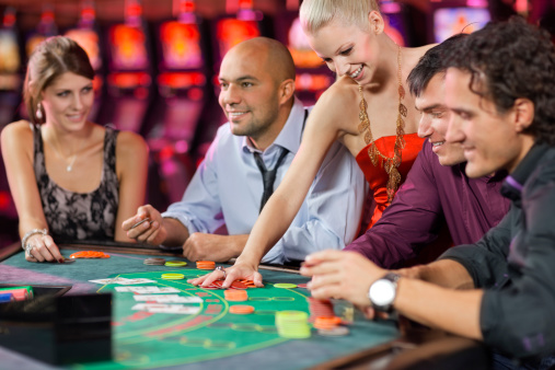 group of people playing blackjack in the casino