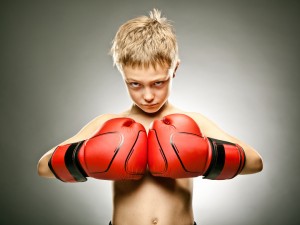 beautiful angry young boy play boxe with gloves